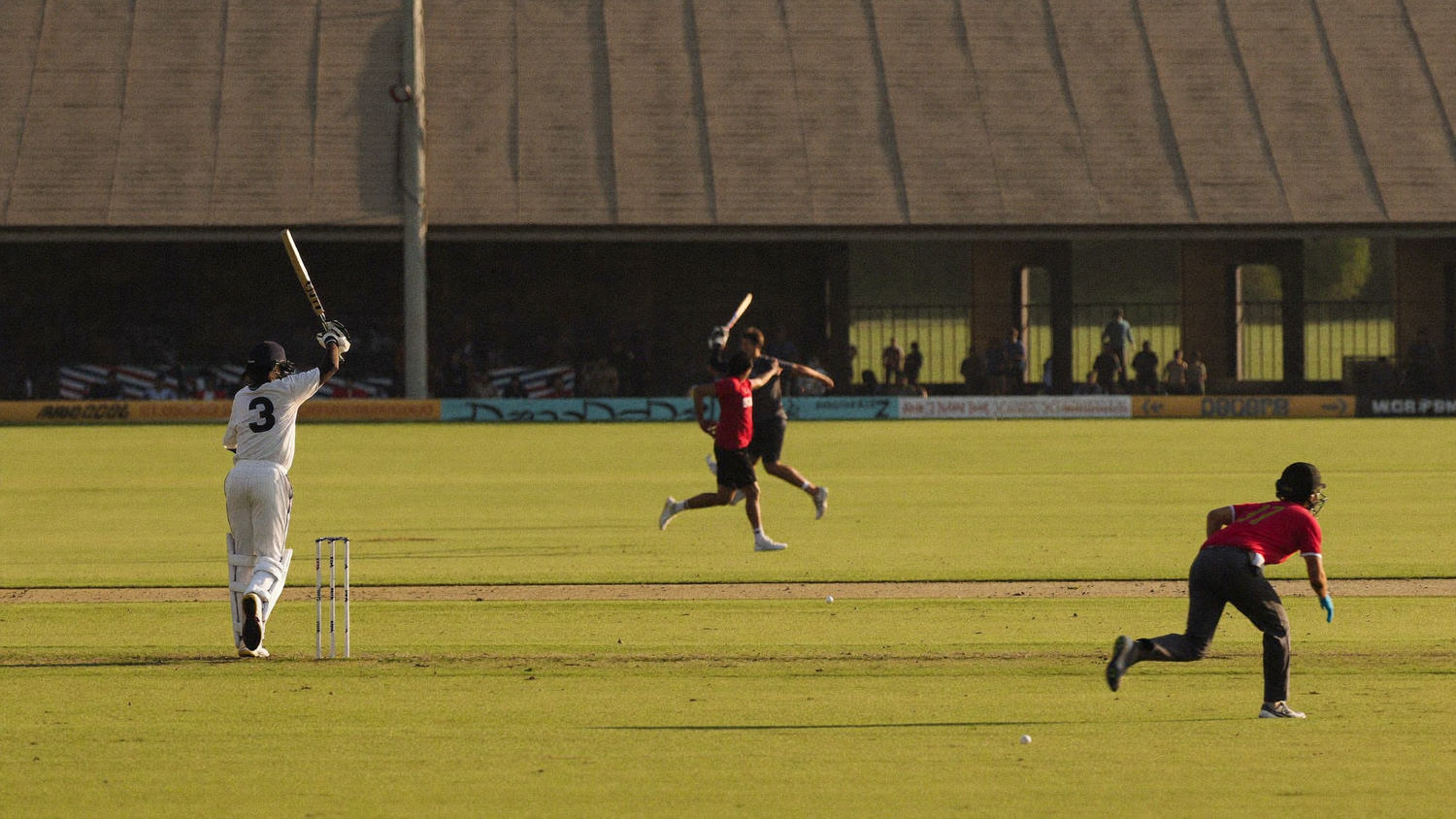 Batsman driving through the line in an afternoon cricket match