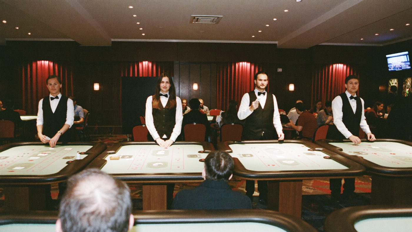 Row of live dealers standing at their stations in a broadcast studio