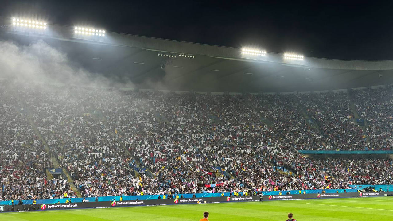 Packed stadium terrace under floodlights at a Malaysian football match